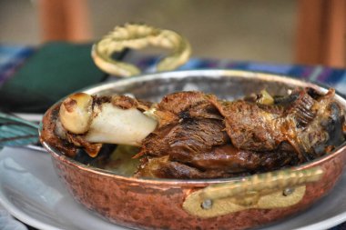 Geleneksel bir tandırda pişirilmiş keçi eti ve tavayla servis ediliyor. Ege adaları et yemekleri