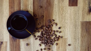 Eski ahşap bir masada kahve ve kahve çekirdeği manzarası.. 