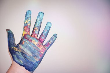Bokeh arka planında renkli boyalı bir çocuk eli