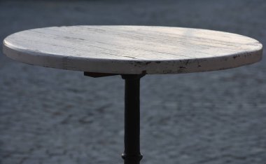 Asfaltlı bir sokakta küçük bir masa.