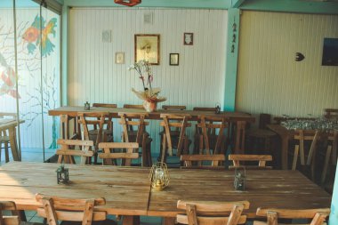 Ege ve Akdeniz tarzı restoranlar, renkli sandalyeler ve masalar, masa örtüleri, çiçekler.
