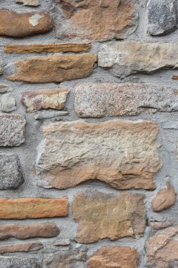 Arkaplan olarak renkli taşlardan yapılmış eski bir duvar, kapat