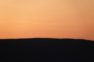 Dağlar arasında turuncu gün batımı. Gün batımında dağ silueti