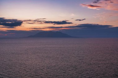 Gkeada 'dan Semendirek Adası manzarası. Gün batımı ve dağların üzerindeki bulutlar. Gökçeada, Çanakkale, Türkiye.