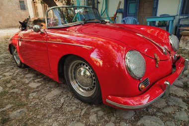 Yoldaki Vintage Porsche 'nin ön görüntüsü. Bir Ege kasabasının sokaklarında klasik kırmızı Porsche arabası. Klasik spor araba, kırmızı klasik Porsche.