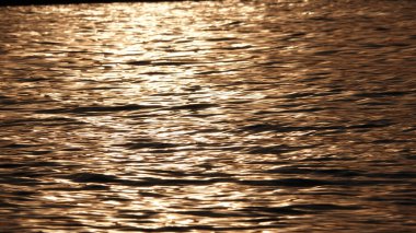 Akşam güneşinin altında deniz yüzeyini görmek