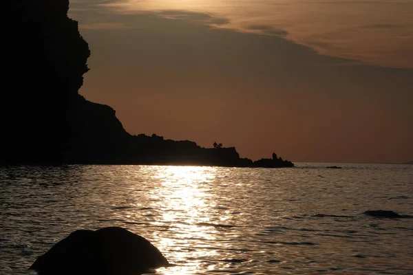 Ein Einsamer Mann Sitzt Bei Sonnenuntergang Auf Den Klippen Silhouette — Stockfoto