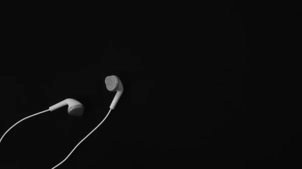 黒い背景の白いヘッドフォン — ストック写真