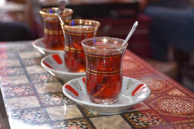 Tavla masasında 3 çay bardağı çay ve kaşık manzarası