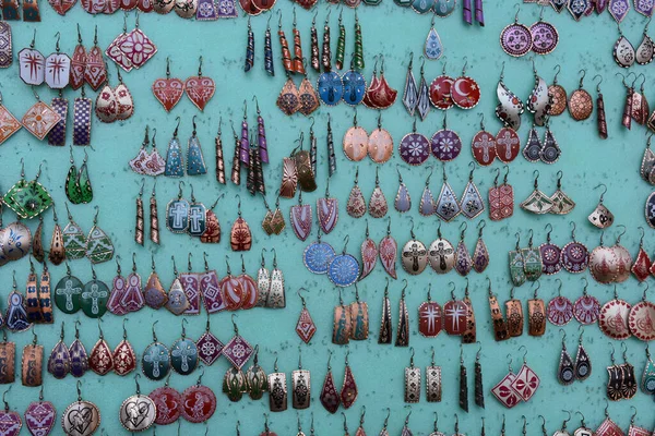 Yeşil arka planda hediye olarak gösterilen otantik küpeler, izole edilmiş