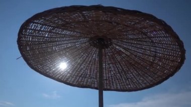 4K plaj şemsiyesi rüzgardan sallanıyor ve gökyüzünde uçan kuşlar
