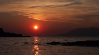 Gün batımını hızlandıran sahildeki deniz ve dağ manzarası