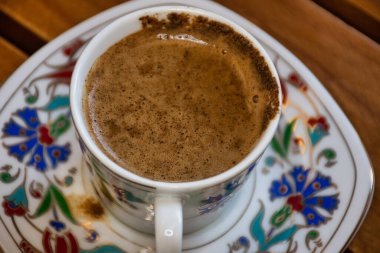 Bir fincan Türk kahvesi, ahşap masa, geleneksel Ramazan içeceği.