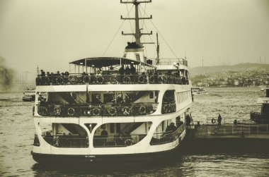 Karakoy, İstanbul / Türkiye - 04 / 04 / 2022: İstanbul, Türkiye 'deki Karakoy feribot limanından manzara. İstanbul 'da Boğaz' da bir feribot naklediliyor. Nostaljik konsept, klasik renkler. Siyah ve beyaz.