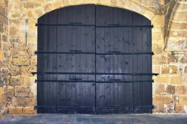 Büyük ahşap kapıları olan eski bir kale duvarı. Retro ahşap kapılar kale kayası, her amaç için harika tasarım.