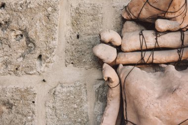 Taşlardan, tahtalardan ve kablolardan yapılmış soyut insan heykeli bir duvarın önünde yükseliyor. İşi yapan kişi anonim, sokakta bırakılmış. İzmir, Türkiye 09.28.2018