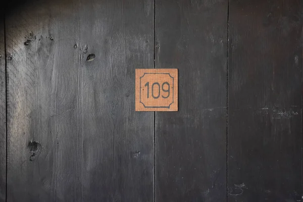 A mysterious wooden antique door with the number 109 on it. Can be used for cinematographic, horror, halloween wallpaper, cards