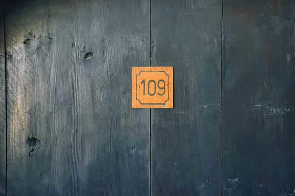 A mysterious wooden antique door with the number 109 on it. Can be used for cinematographic, horror, halloween wallpaper, cards