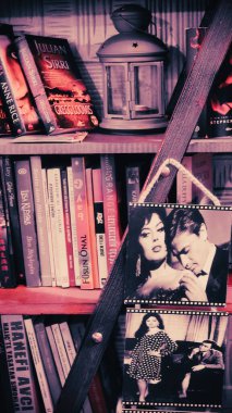 En ünlü Türk film sanatçılarının kartları, çeşitli Türk romanları, kitapları ve bir mum lambasıyla kütüphane manzarası