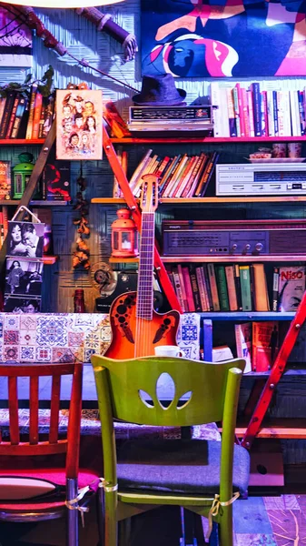 本棚の本 ヴィンテージのフィリップス グランディグ ラジオのヴィンテージ オブジェクト そしてその前に立つクラシック ギター 空のテーブルと椅子10 2022イスタンブール トルコ — ストック写真