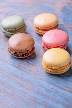 Eski ahşap bir masaya farklı tatlarda makarna yığılmış..