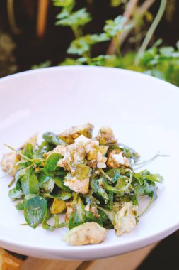 Beyaz tabak kuzu marulu ve roka salatası ve taze peynir..