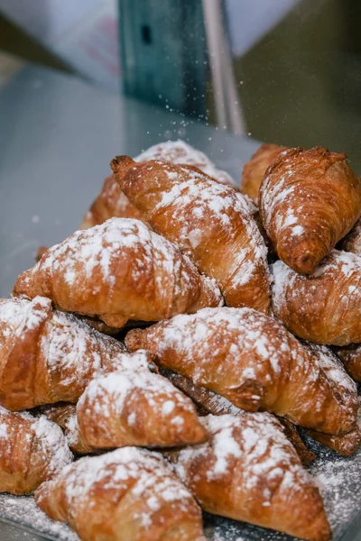 Bäcker Gießt Puderzucker Auf Einen Haufen Croissants — Stockfoto