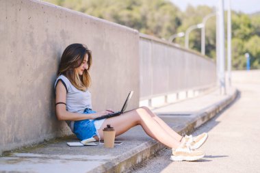 Digital nomad girl working from a natural setting.
