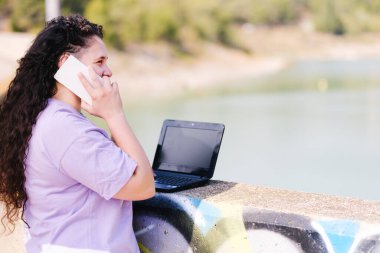 Digital nomad girl with curly brunette hair.