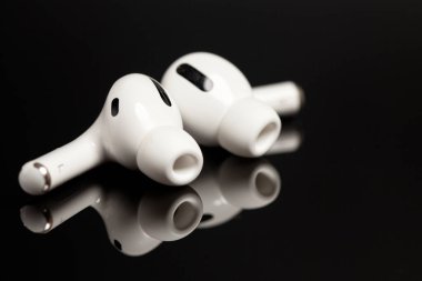 Siyah arkaplanda yansımalı kablosuz kulaklıklar..