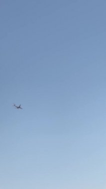 Gökyüzünde parlak bir günde uçan bir uçak ekranı soldan sağa geçiriyor - fotokopi uzayı ile dikey arkaplan videosu