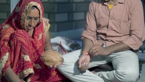 Indian sister tying rakhi, Raksha bandhan to brother's wrist during festival or ceremony. — Stock Video