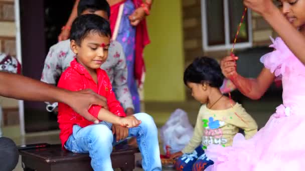 Raksha Bandhan ou Bhai Dooj tradição festival conceito. Bonita irmãzinha fazendo pooja de seu irmão por ocasião de rakhi ou tika — Vídeo de Stock
