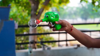Sabun köpüğü tabancası tutan kimliği belirsiz çocuklar. Balon üfleyicili çocuklar.