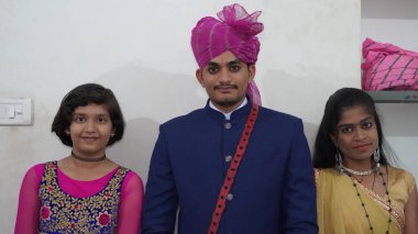 21 Kasım 2021 Reengus, Rajasthan, Hindistan. Küçük kardeşleriyle Hintli yakışıklı damat.