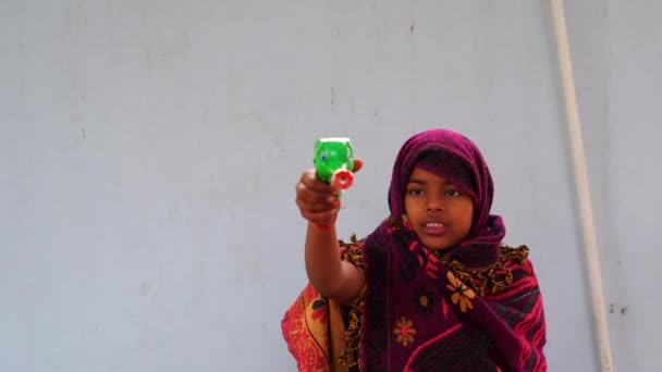 4K görüntü, Hintli küçük kız arka bahçede sprey tabanca oynuyor. Kız sabah eğleniyor.. — Stok video