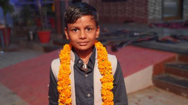 Sarı çiçekli sevimli ve masum Asyalı çocuk kameramana bakıyor..