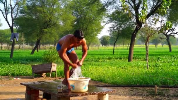 Rajasthani clipe aldeia rural, um homem tomando um banho no início da manhã na temporada de inverno. Imagens de câmera super lenta. — Vídeo de Stock