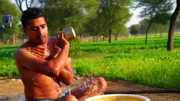 Hombre tomando baño al aire libre, hombre indio bañándose en estilo tradicional. Hombre joven bañándose en la madrugada de invierno. — Vídeos de Stock