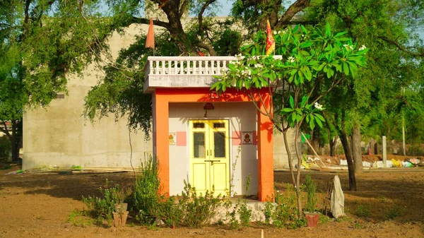 Stara Hinduska Świątynia Malowana Pomarańczowo Położona Środku Trawy Otoczona Zielonymi — Zdjęcie stockowe