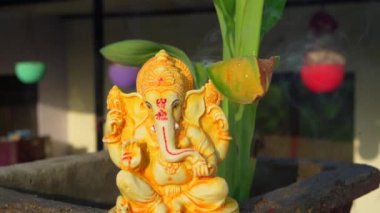 Water splash after pray, Ganpati festival, Water splash on lord ganesha sculpture with home background.