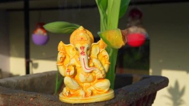 Water splash after pray, Ganpati festival, Water splash on lord ganesha sculpture with home background.