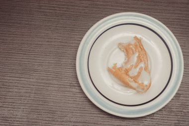 Beyaz bir tabağın mutfak fotoğrafı bir kaşık ekmek ve yoğunlaştırılmış sütle fıstık kreması. Isır.