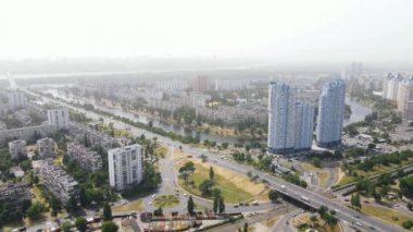 Çevresinde yeşil ağaçlar ve yol kenarında gökdelenler olan yerleşim alanları.