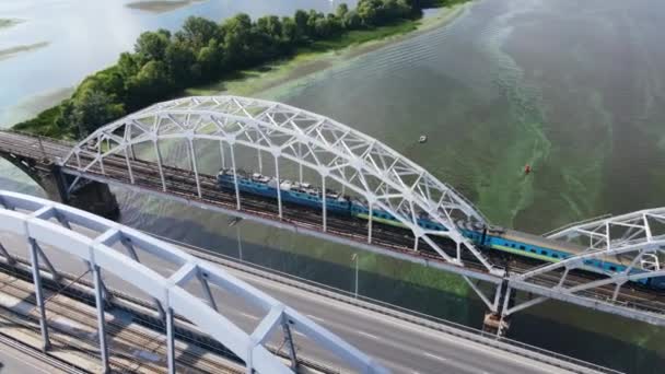 Vista aérea del tren de superficie que pasa por el puente sobre el río — Vídeo de stock