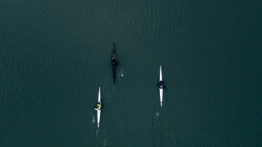 Güneşli bir günde nehir suyunda yüzen iki adamın kano üzerindeki eğitiminin en üst görüntüsü.