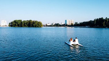 Genç aşıkların hava manzarası şehrin parkında bir katamara biniyor.