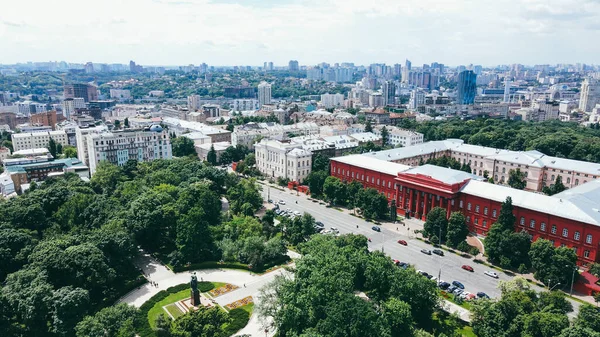 Büyük şehrin binalarının ve parkının üzerinden uçmak. Şehir manzarasının hava görüntüsü