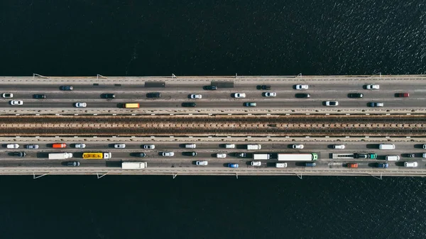 Vista aérea de los coches y el metro que pasa el puente sobre el río en la ciudad Imagen De Stock