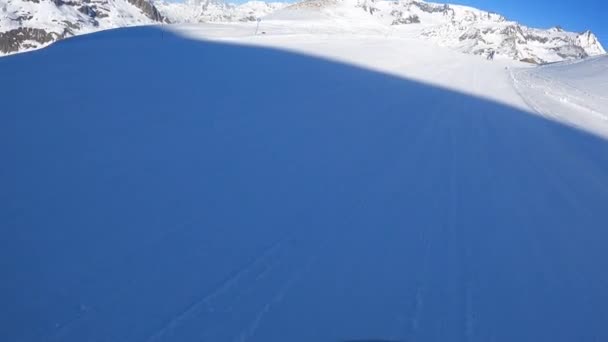 Un snowboarder desciende a la velocidad de una montaña en los Alpes — Vídeos de Stock